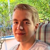 a young man sitting in a chair with a smile on his face